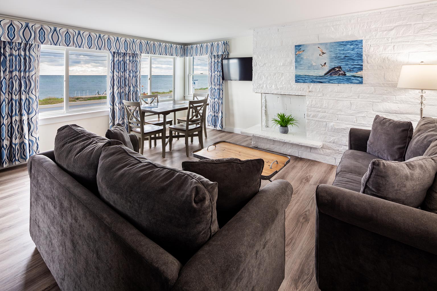 Breakwater Hotel Suite with seating area, table and chairs, and ocean view.