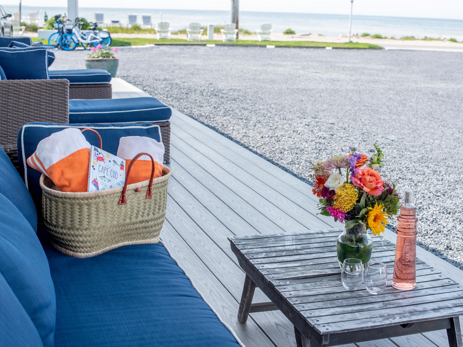 Bright outdoor hotel seating with wine and flowers