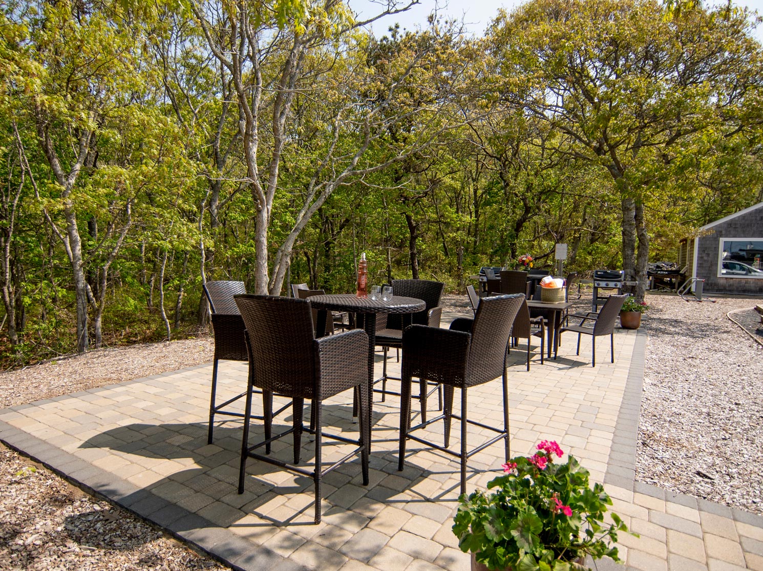 Outdoor seating area with tall tables and stools.